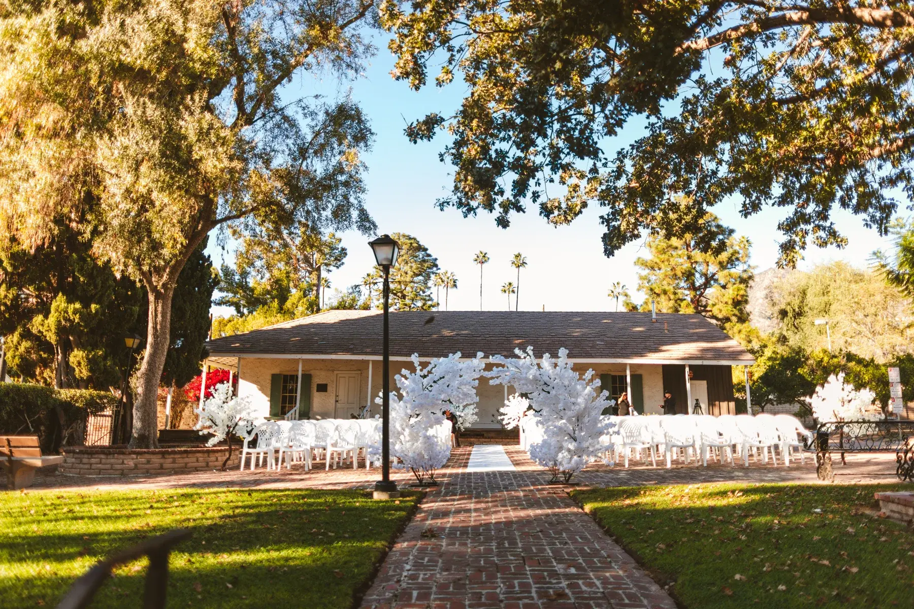 An outdoor ceremony with the white cherry blossom arch