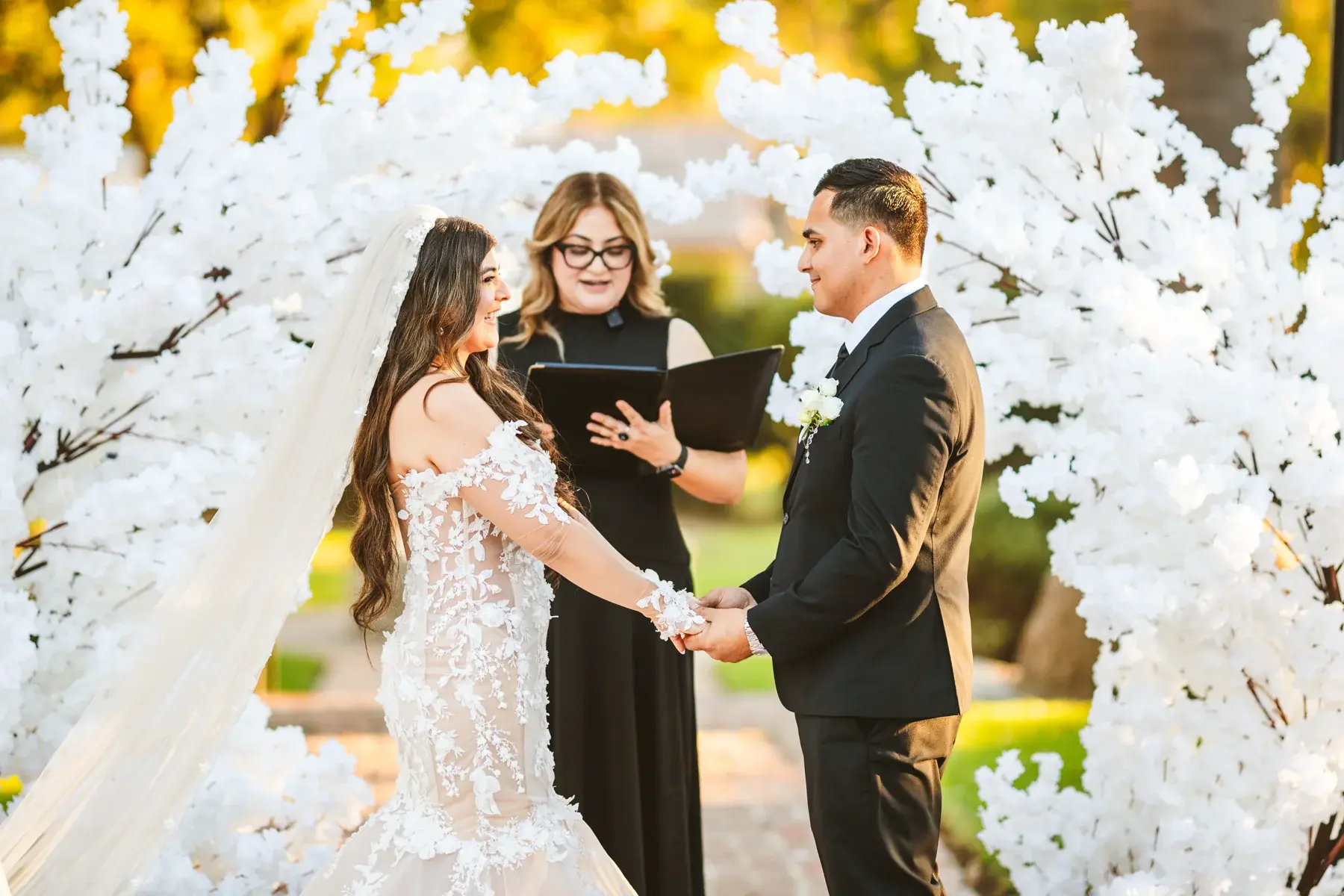 Wedding ceremony framed by the white blossom arch