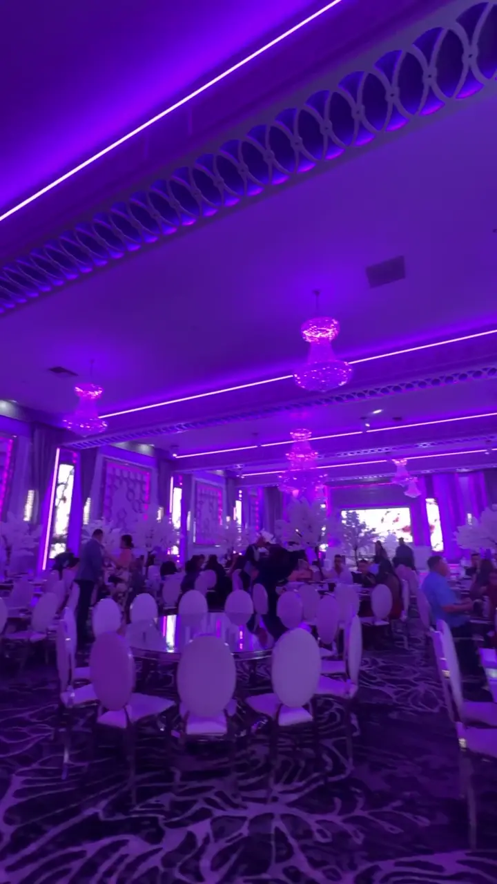 Cherry blossom trees among reception tables under evening lighting