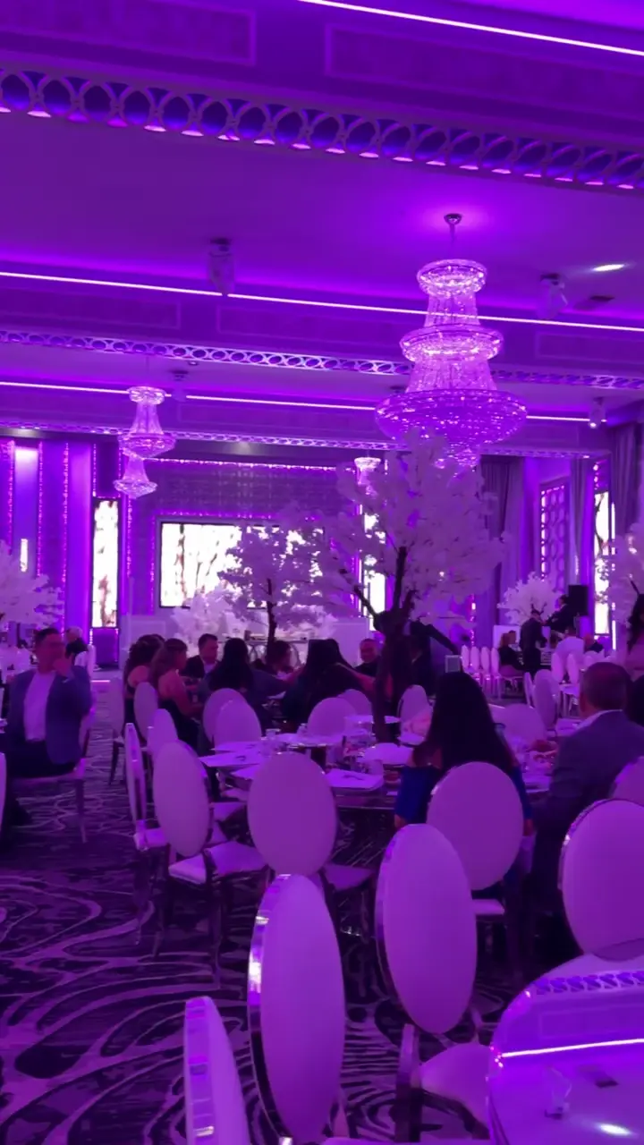 Wedding guests dining among white cherry blossom trees